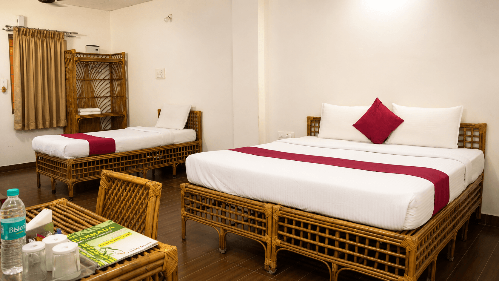 Deluxe bedroom with rattan furniture and red accent bedding at Sharmada