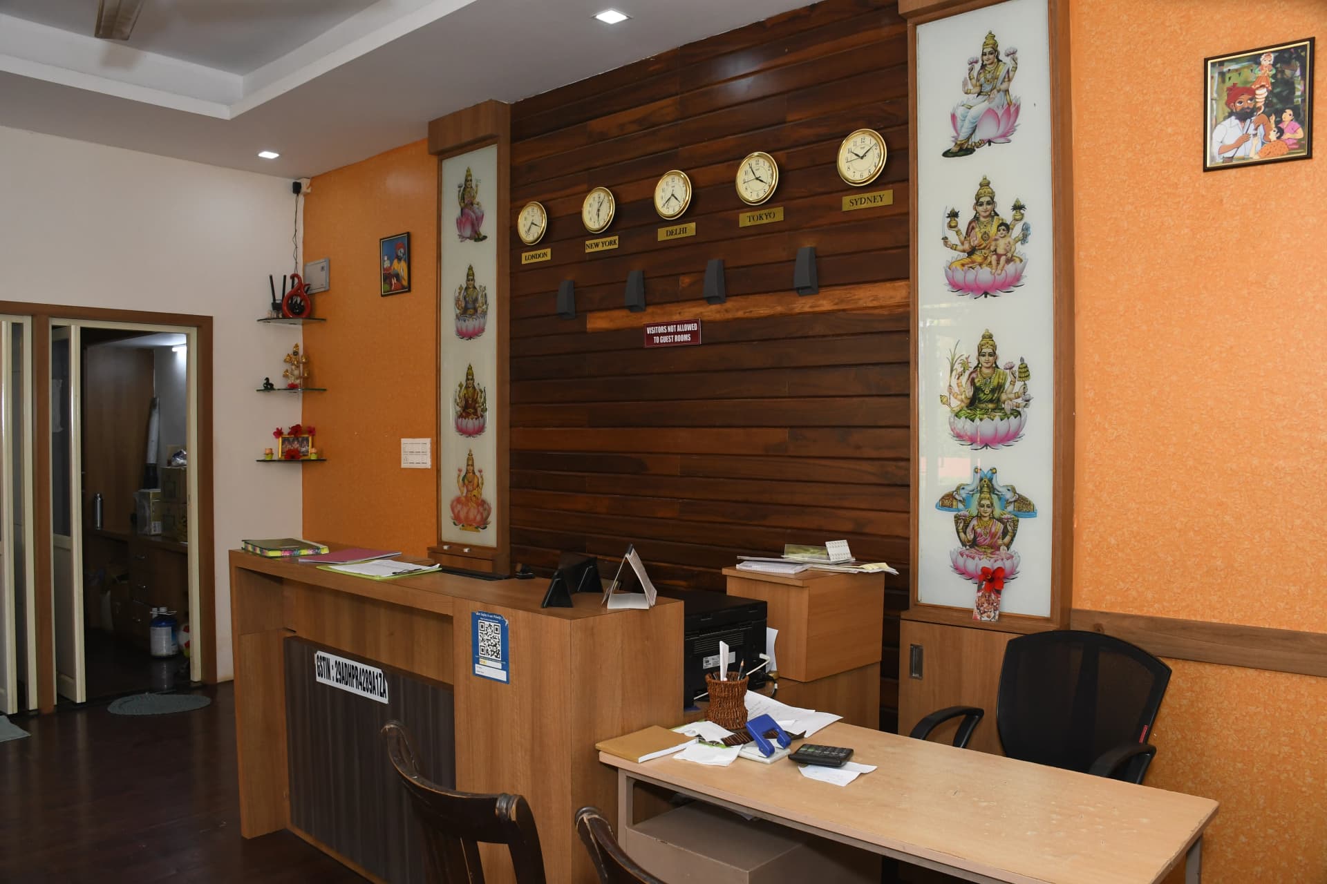 Front desk reception with teak panelling and world clocks at Sharmada Hidden Nest