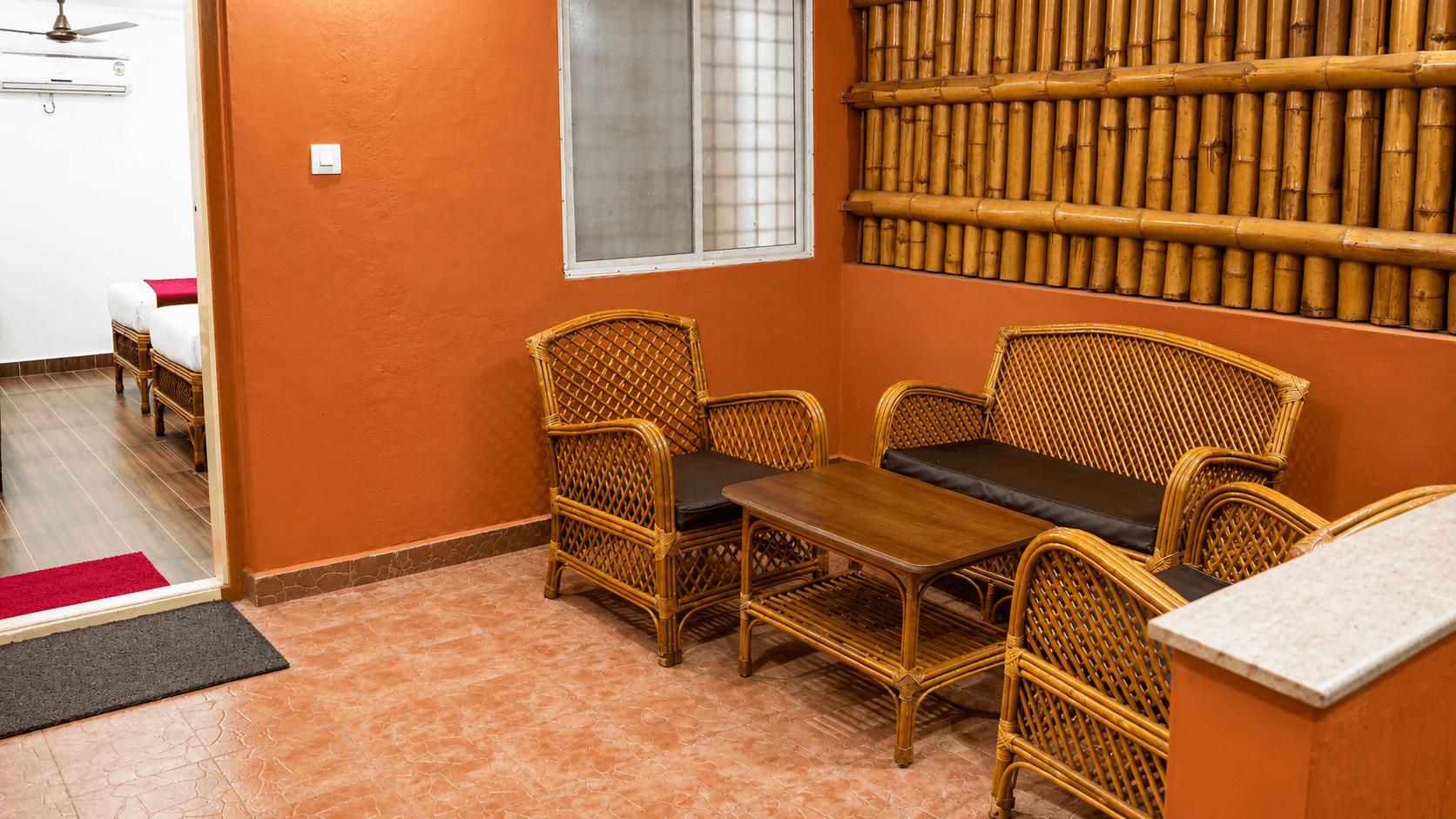 Room veranda sitting area with bamboo wall and rattan chairs at Sharmada