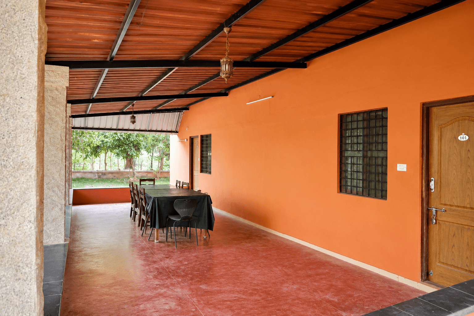 Covered veranda with dining table outside room at Sharmada Hidden Nest